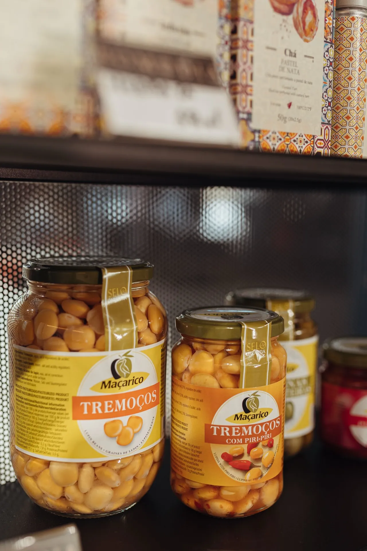 Słoiki tremoços Macarico, portugalskiego łubinu w zalewie, na czarnej półce sklepiku
